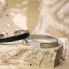 2 bracelets cuir homme femme posé sur une pierre beige