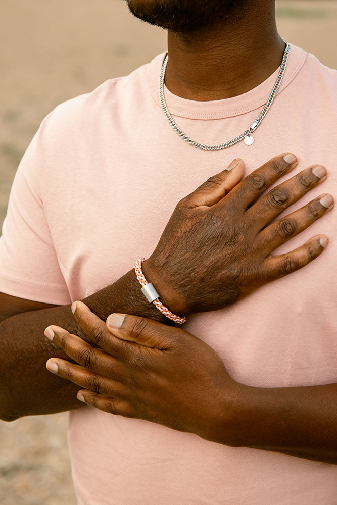 bracelet naturel rose en coton et acier inoxydable porté par un homme