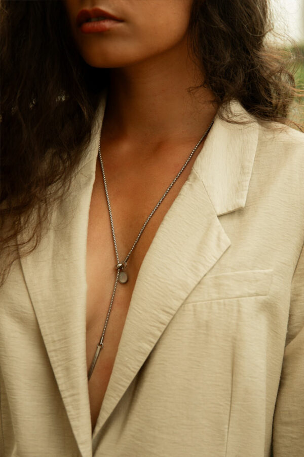 collier longueur réglable en acier inoxydable et nacre blanche porté par une femme