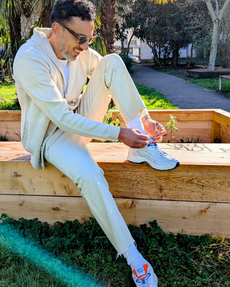 Homme stylé portant des bracelets unisexes durables et lacant ses chaussures